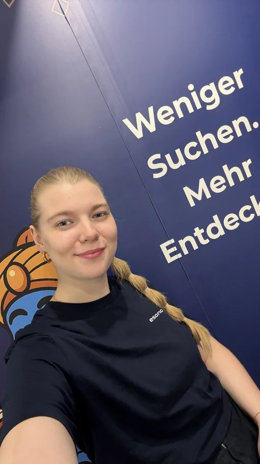 Person vor blauem Hintergrund mit Text: "Weniger Suchen. Mehr Entdecken."
