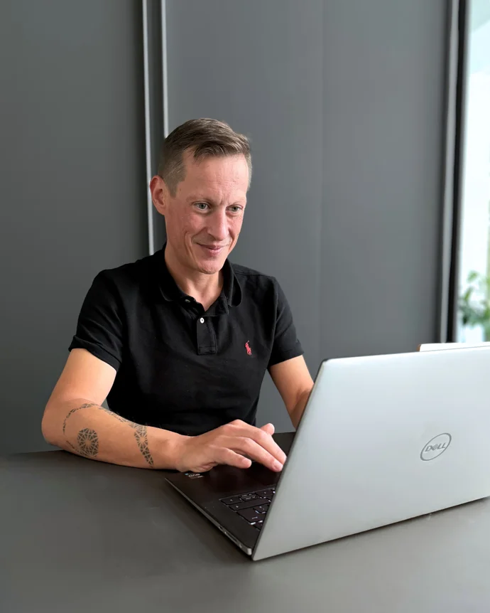 Person am Laptop in einem modernen Büro, konzentriert arbeitend.
