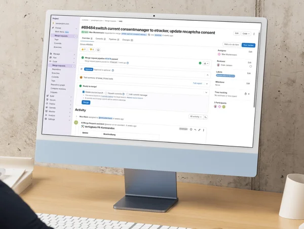 Computerbildschirm zeigt eine Projektmanagement-Software mit Aufgabenliste. Nutzer arbeitet an einem Schreibtisch.