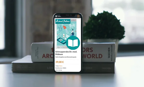 Smartphone auf Büchern zeigt ein digitales Zeitschriftenabo mit Illustration; Titel: "Schnupperabo Dr. med. Mabuse".