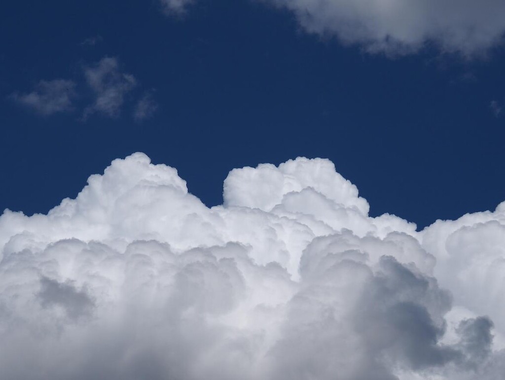 Bild einer weißen Wolke vor blauem Himmel.