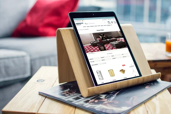 Tablet auf Holzständer mit Wohnzeitschrift in Luxuseinrichtung nutzen.
