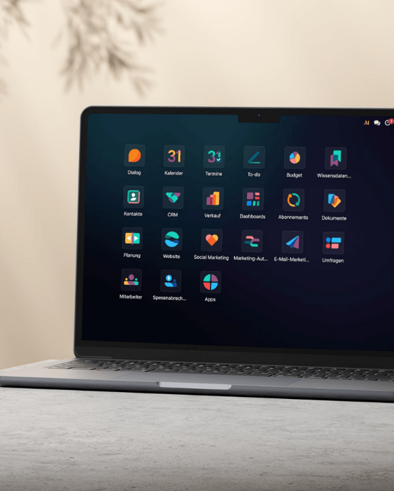 Laptop auf Tisch mit geöffnetem Display, zeigt Symbole einer Desktop-Oberfläche unter neutralem Licht.